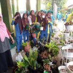 Harneti foto bersama dengan siswa donatur tanaman hias. (Dok. Eni)