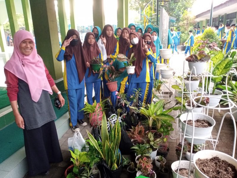 Harneti foto bersama dengan siswa donatur tanaman hias. (Dok. Eni)